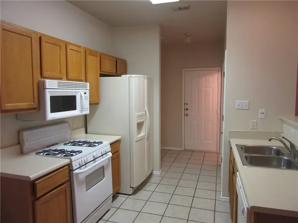 a kitchen with a stove a refrigerator and a sink