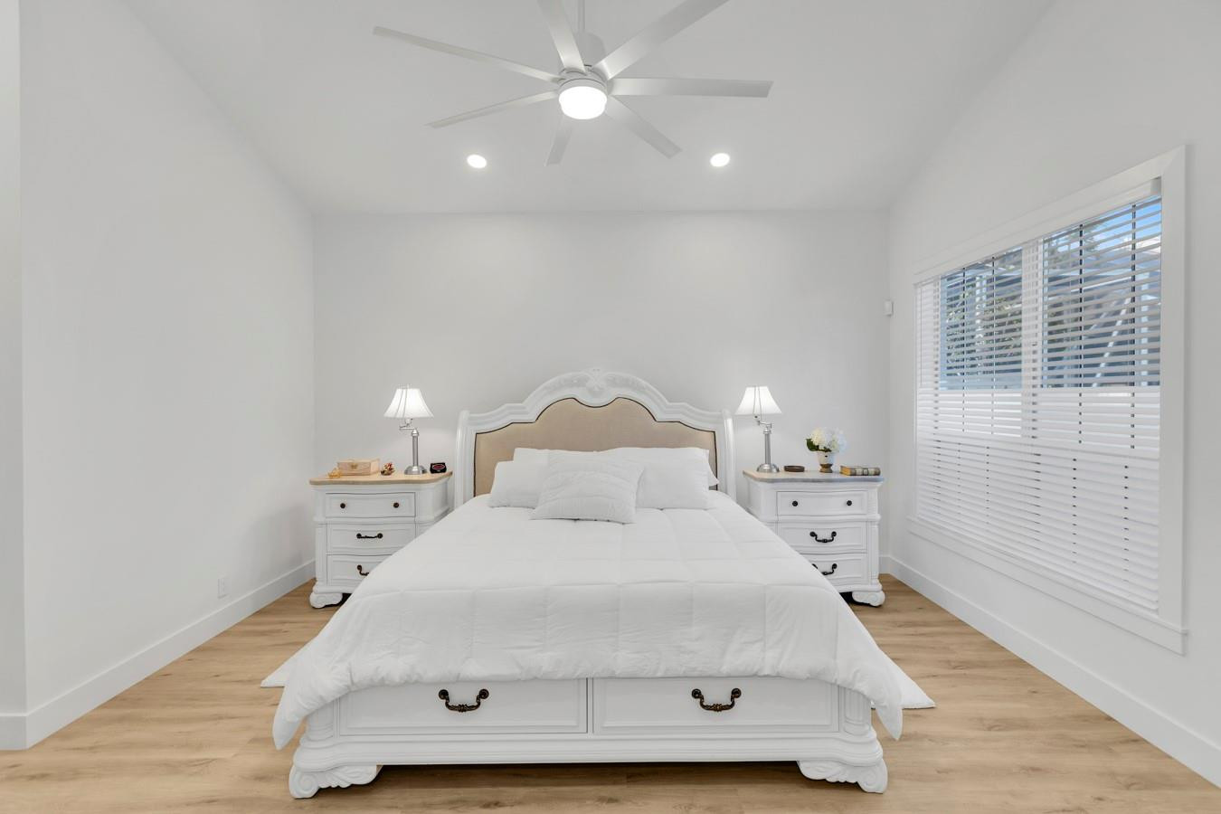 6391 Northwest 23rd Lane Boca Raton, FL 33434 - Photo 14 of 49 a large bed sitting in a bedroom next to a window and a chandelier