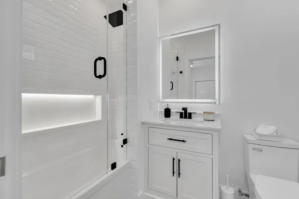 a bathroom with a sink a toilet and shower