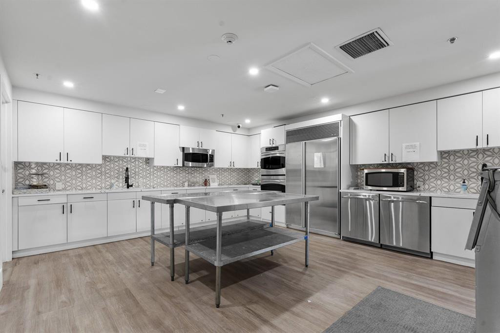 6391 Northwest 23rd Lane Boca Raton, FL 33434 - Photo 45 of 49 a kitchen with white cabinets and stainless steel appliances