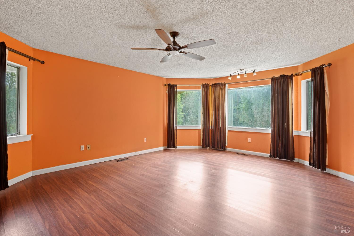 681 Branscomb Road Laytonville, CA 95454 - Photo 14 of 27 a view of an empty room with window wooden floor and a ceiling fan