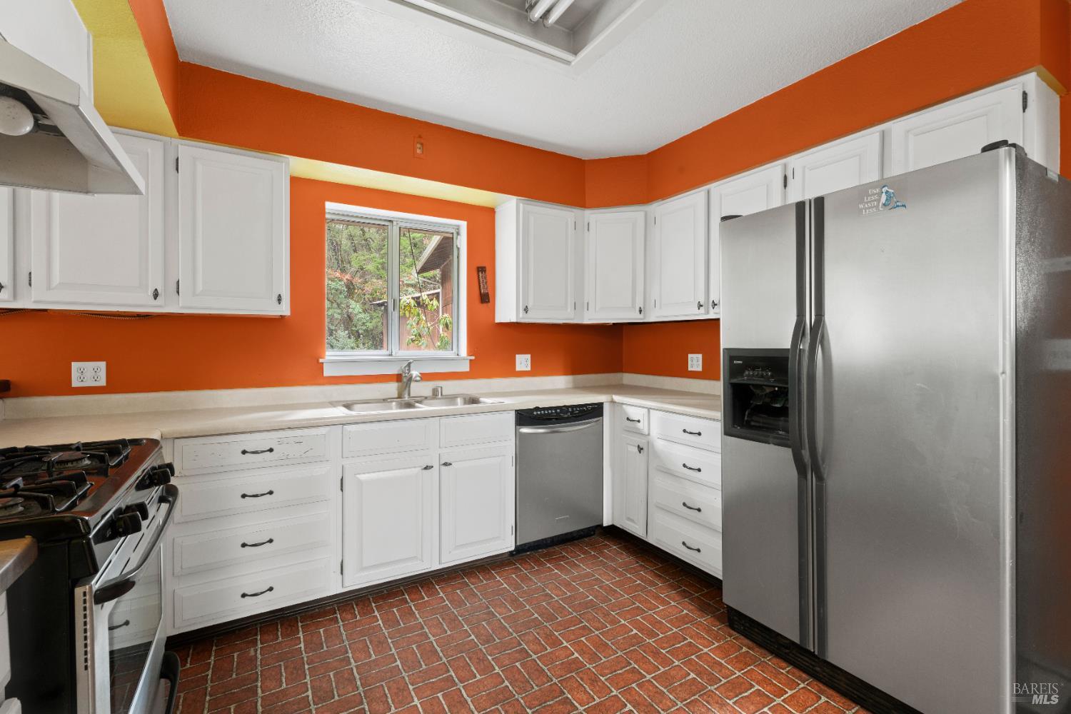 681 Branscomb Road Laytonville, CA 95454 - Photo 8 of 27 a kitchen with white cabinets a window and stainless steel appliances