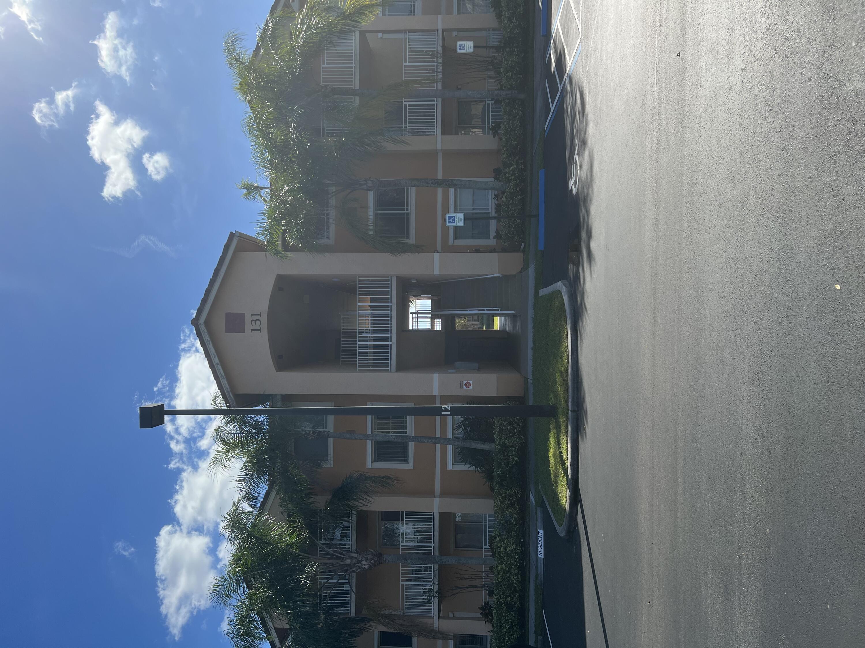 131 Southwest Palm Drive, Unit 203 Port St. Lucie, FL 34986 - Photo 1 of 13 a front view of a house with a yard