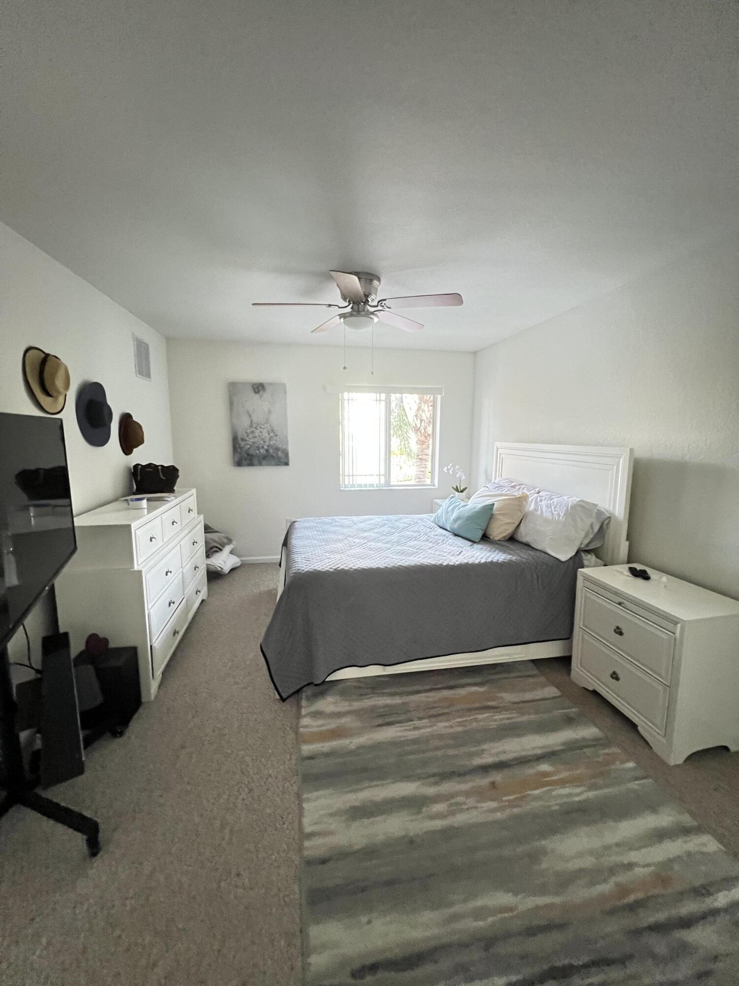131 Southwest Palm Drive, Unit 203 Port St. Lucie, FL 34986 - Photo 4 of 13 a bedroom with a bed and a couch