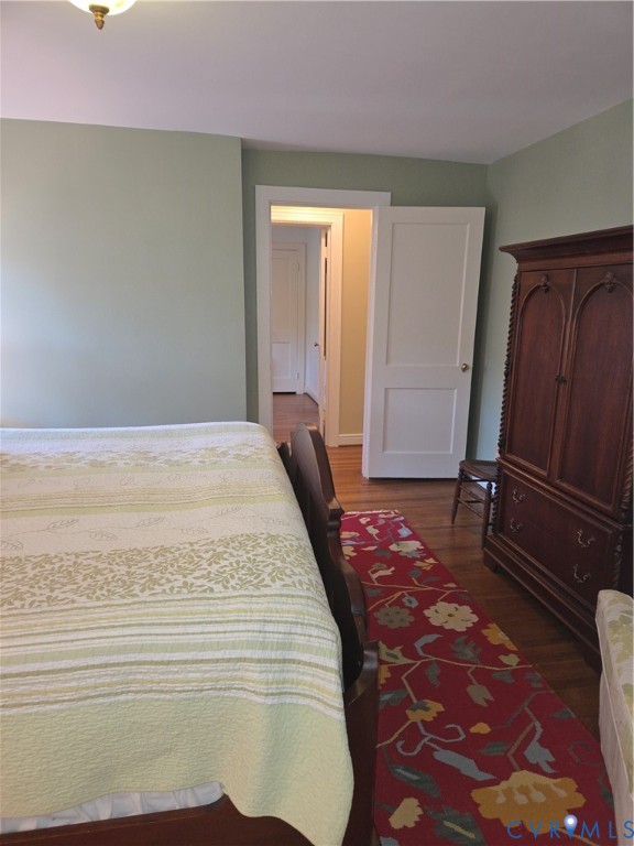 7733 Rock Creek Road Henrico, VA 23229 - Photo 42 of 73 a bedroom with a bed and dresser with wooden floor