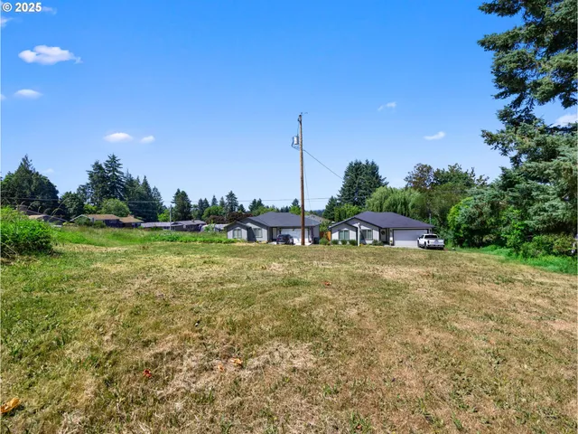 a green field with lots of trees in the background