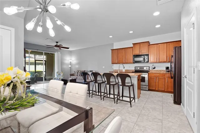 a large kitchen with a table chairs refrigerator and cabinets