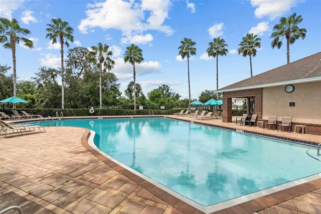 a view of a swimming pool with a patio and a yard