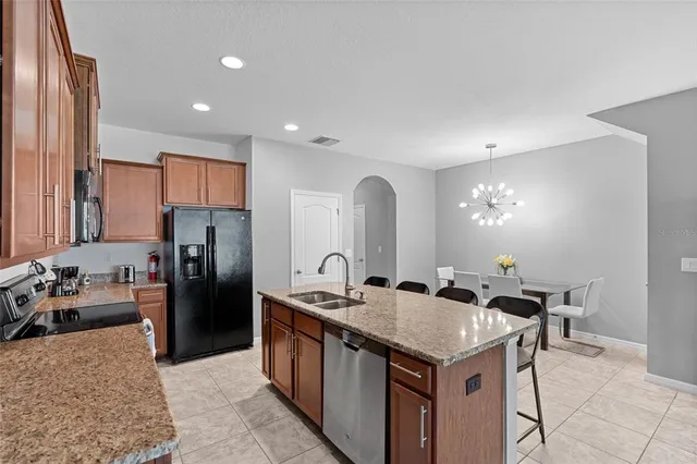 a kitchen that has a lot of cabinets a sink and a refrigerator