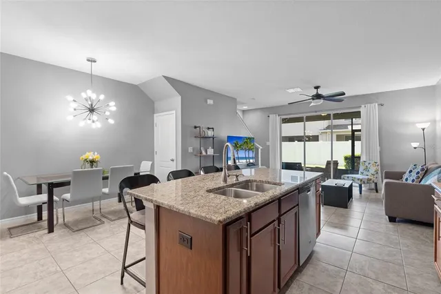 a kitchen with a stove a kitchen island a sink dining table and chairs