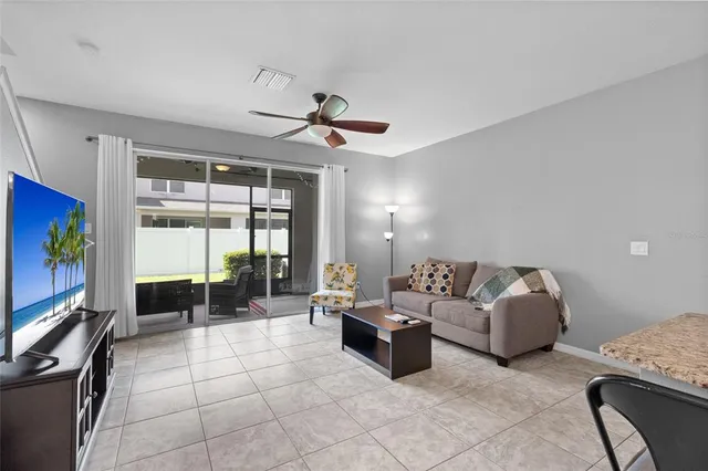 a living room with furniture a flat screen tv and a large window