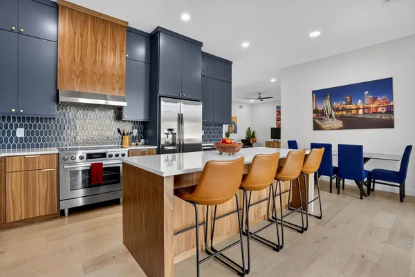 a kitchen with stainless steel appliances kitchen island granite countertop a sink and a refrigerator