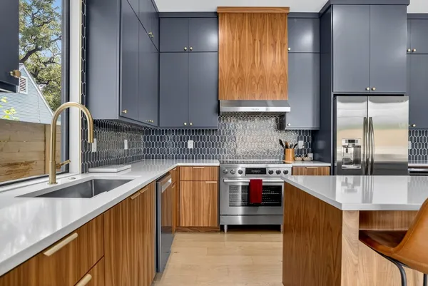a kitchen with stainless steel appliances granite countertop a sink stove and refrigerator