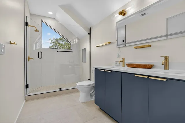 a bathroom with a granite countertop sink mirror toilet and shower