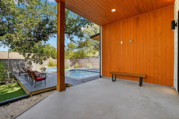 a view of a house with pool fire pit couches and chairs with wooden floor
