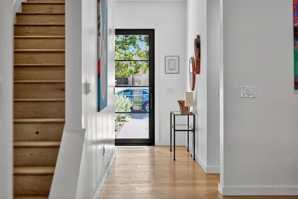 a view of a hallway with wooden floor and entryway