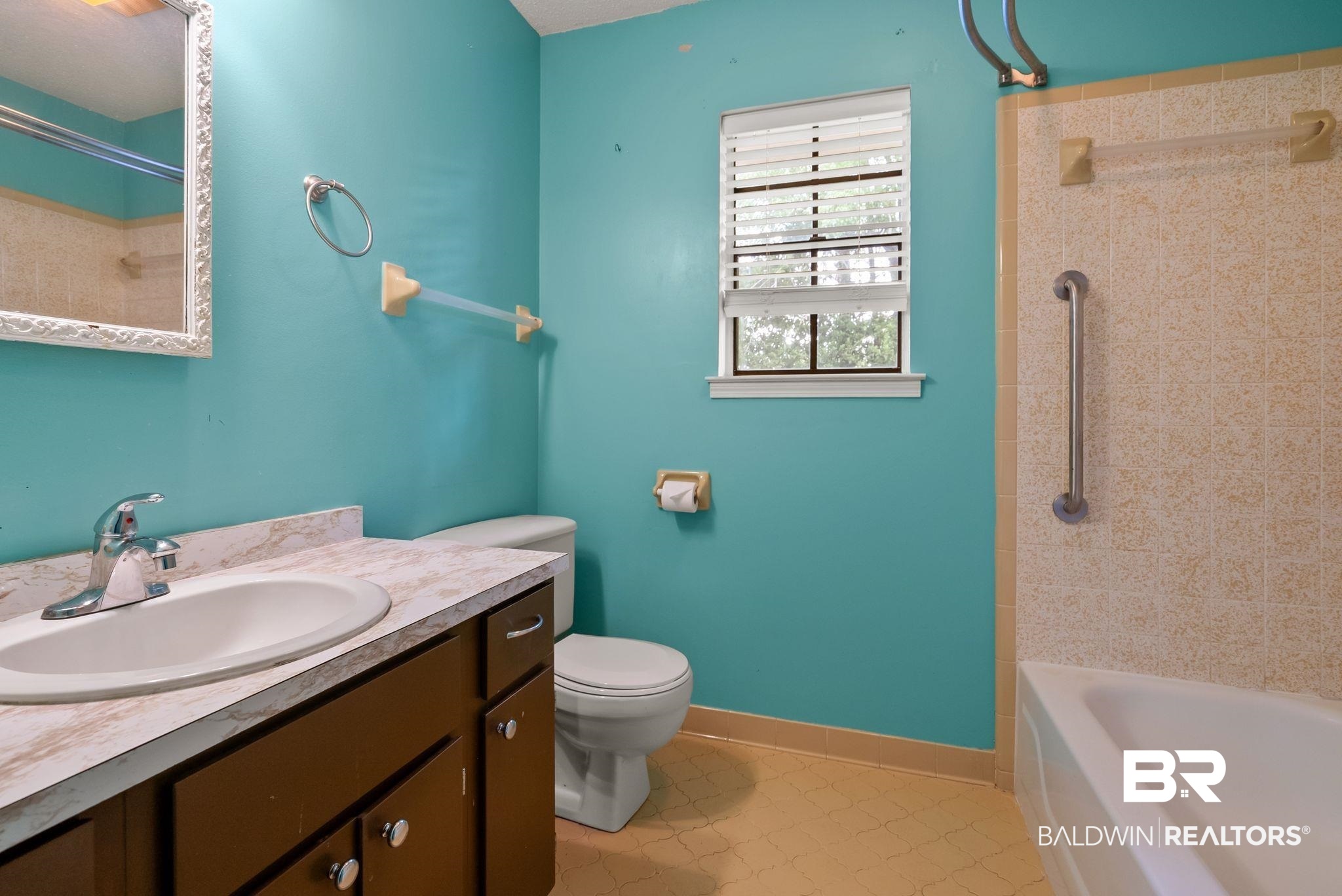 716 North Cedar Street Foley, AL 36535 - Photo 18 of 25 Bathroom featuring a white drop-in sink with a chrome faucet, a wood-finish vanity with silver hardware, and a white toilet
