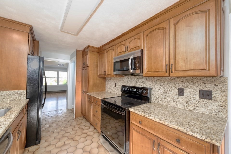 48 Conrad Street Braintree, MA 02184 - Photo 12 of 36 a kitchen with stainless steel appliances granite countertop a stove a sink and a microwave