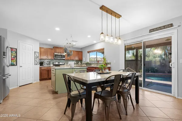 a dining area with a table chairs and a kitchen view