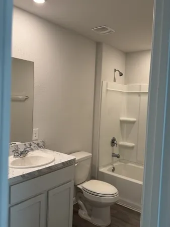 a bathroom with a granite countertop sink toilet and shower