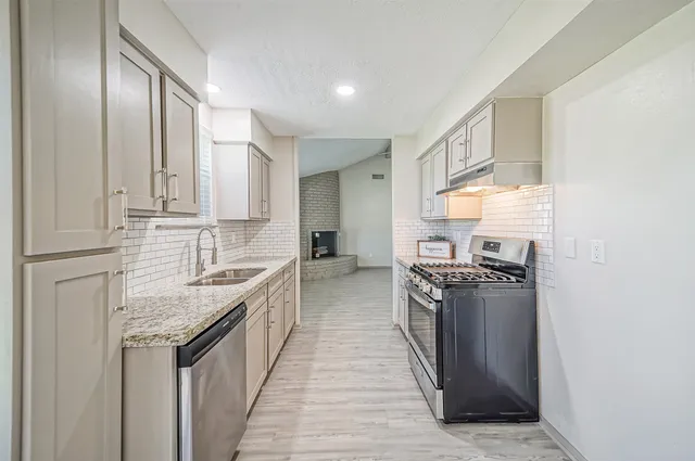 a kitchen with stainless steel appliances granite countertop a stove and a sink