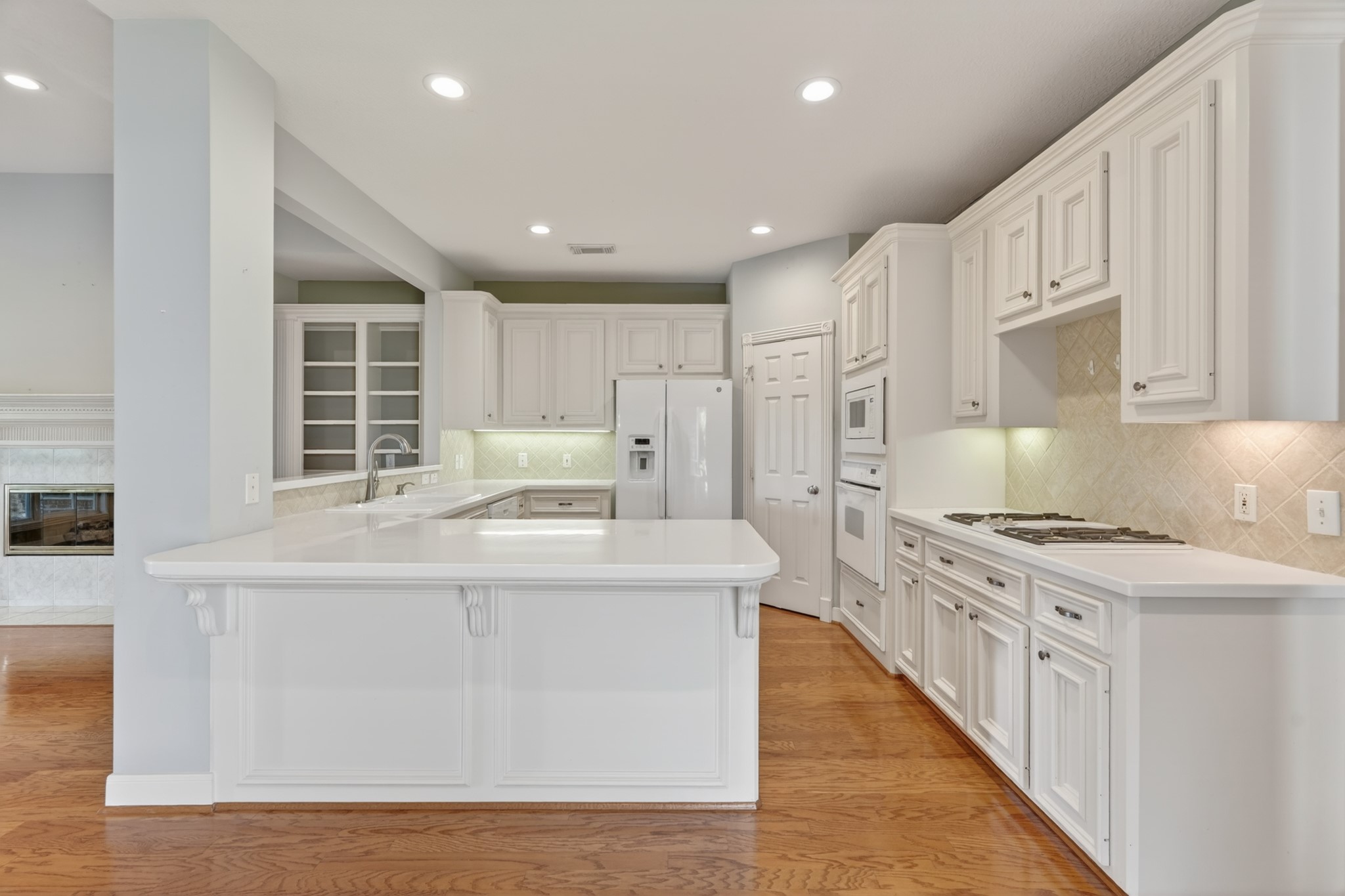 20714 Flora View Court Spring, TX 77379 - Photo 18 of 40 a kitchen with stainless steel appliances granite countertop a white stove top oven a sink dishwasher and a refrigerator with wooden floor