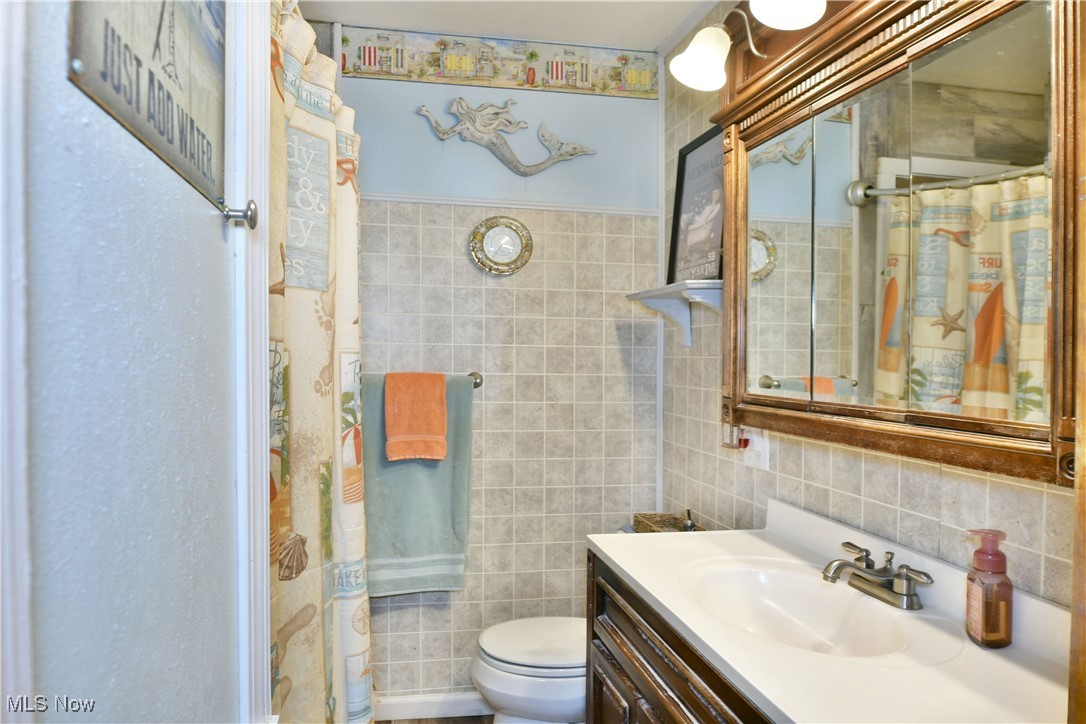 3224 Reeves Road Northeast Warren, OH 44483 - Photo 32 of 49 Full bathroom with tile walls, curtained shower, and vanity