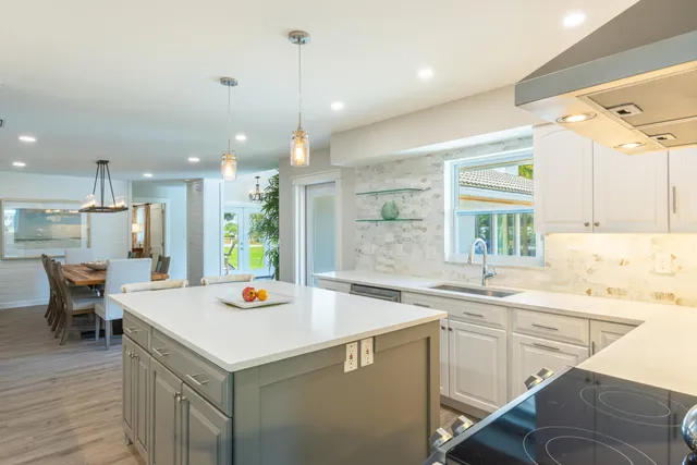a kitchen that has a sink a table and chairs in it