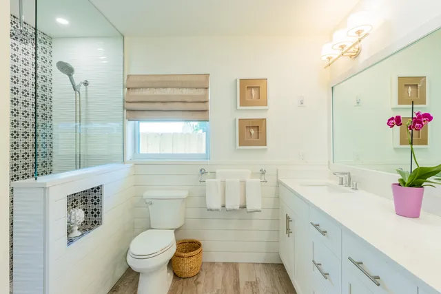 a bathroom with a granite countertop toilet sink and mirror