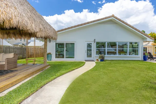 a view of a house with a yard and sitting area