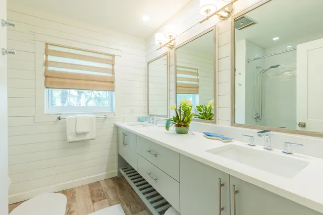 a bathroom with a double vanity sink window and mirror