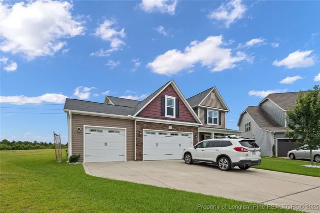a car parked in front of a house with a yard