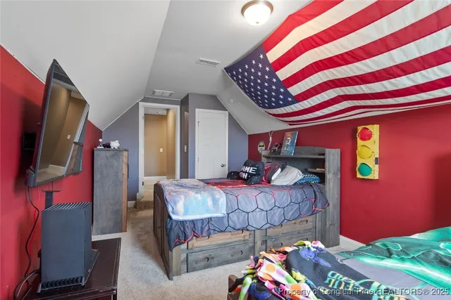 a bedroom with a large bed and a chandelier