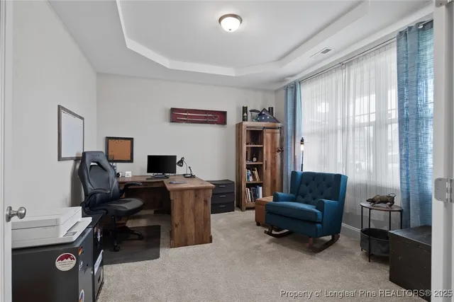 a view of a workspace with furniture and a window