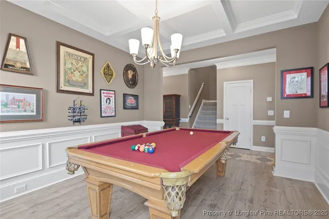 a view of a livingroom with furniture a flat screen tv and wooden floor