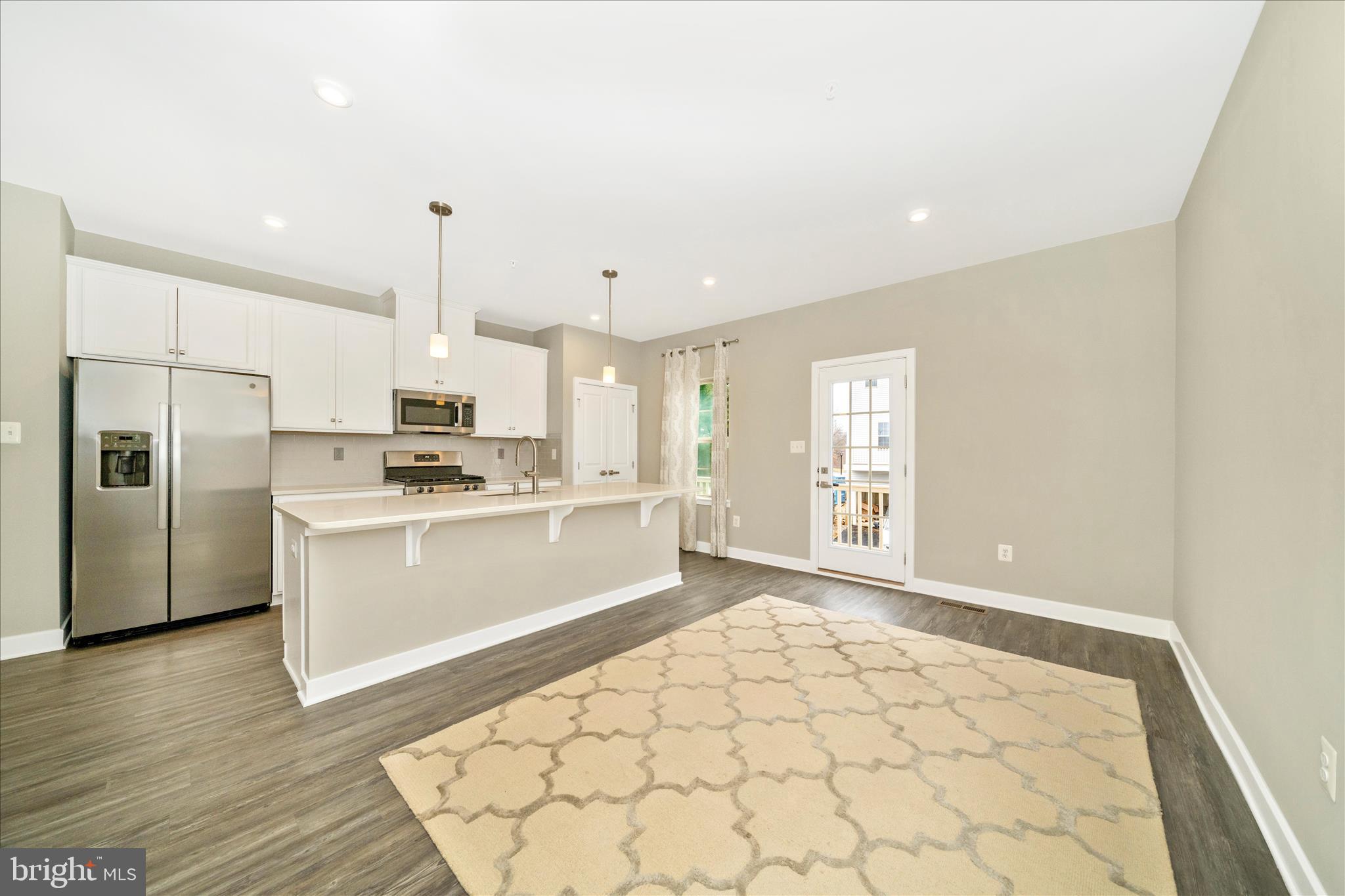9537 Tall Oaks Road Montgomery Village, MD 20886 - Photo 14 of 53 a large white kitchen with stainless steel appliances kitchen island granite countertop a refrigerator a stove a sink and white cabinets with wooden floor
