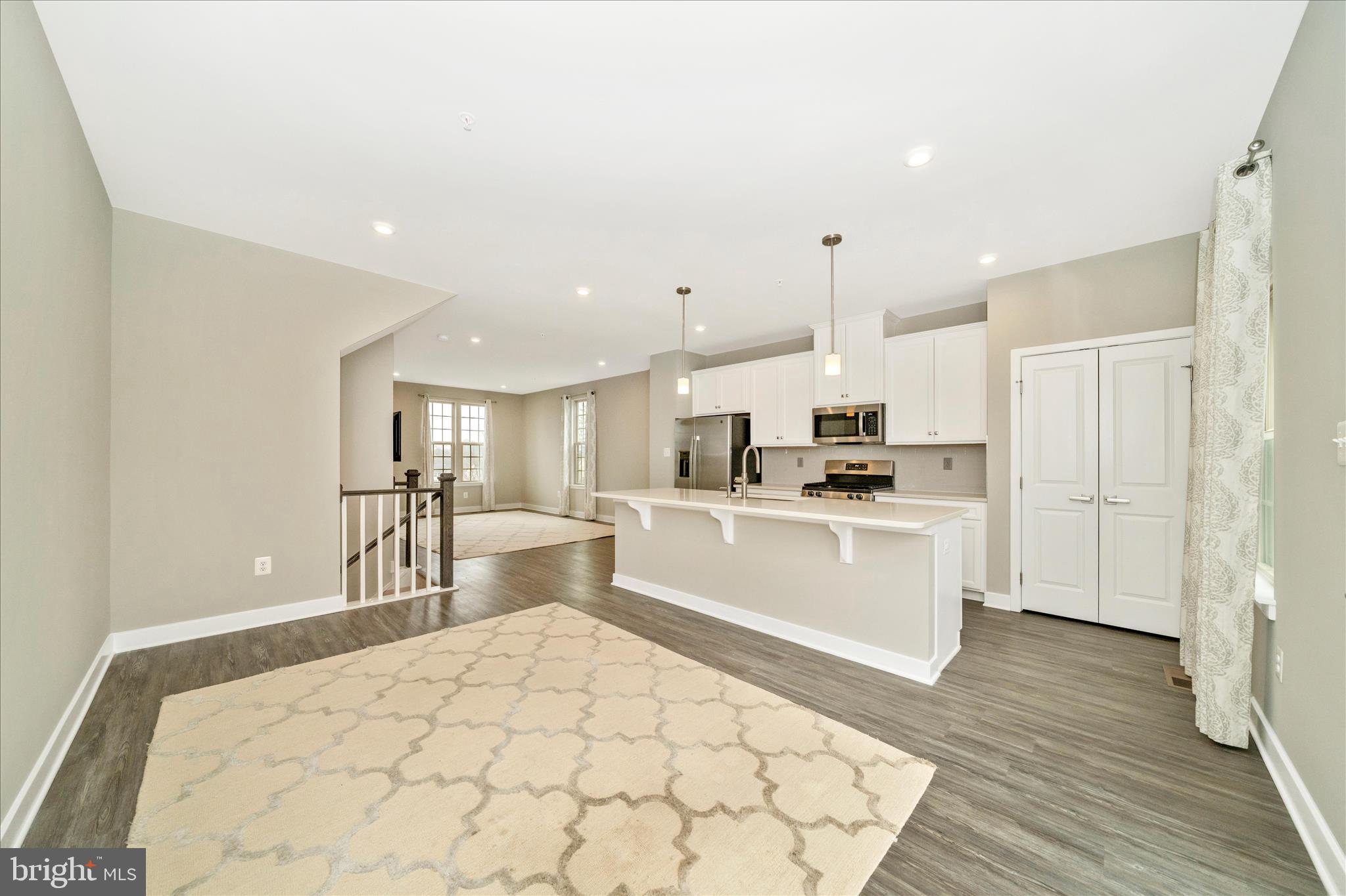 9537 Tall Oaks Road Montgomery Village, MD 20886 - Photo 15 of 53 a large white kitchen with white cabinets and wooden floor