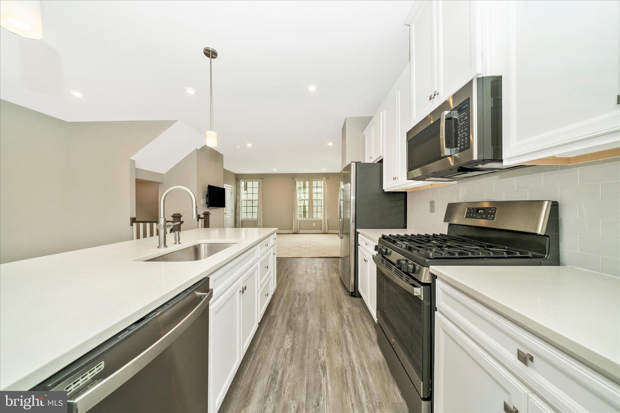 9537 Tall Oaks Road Montgomery Village, MD 20886 - Photo 18 of 53 a kitchen with stainless steel appliances a sink stove and cabinets