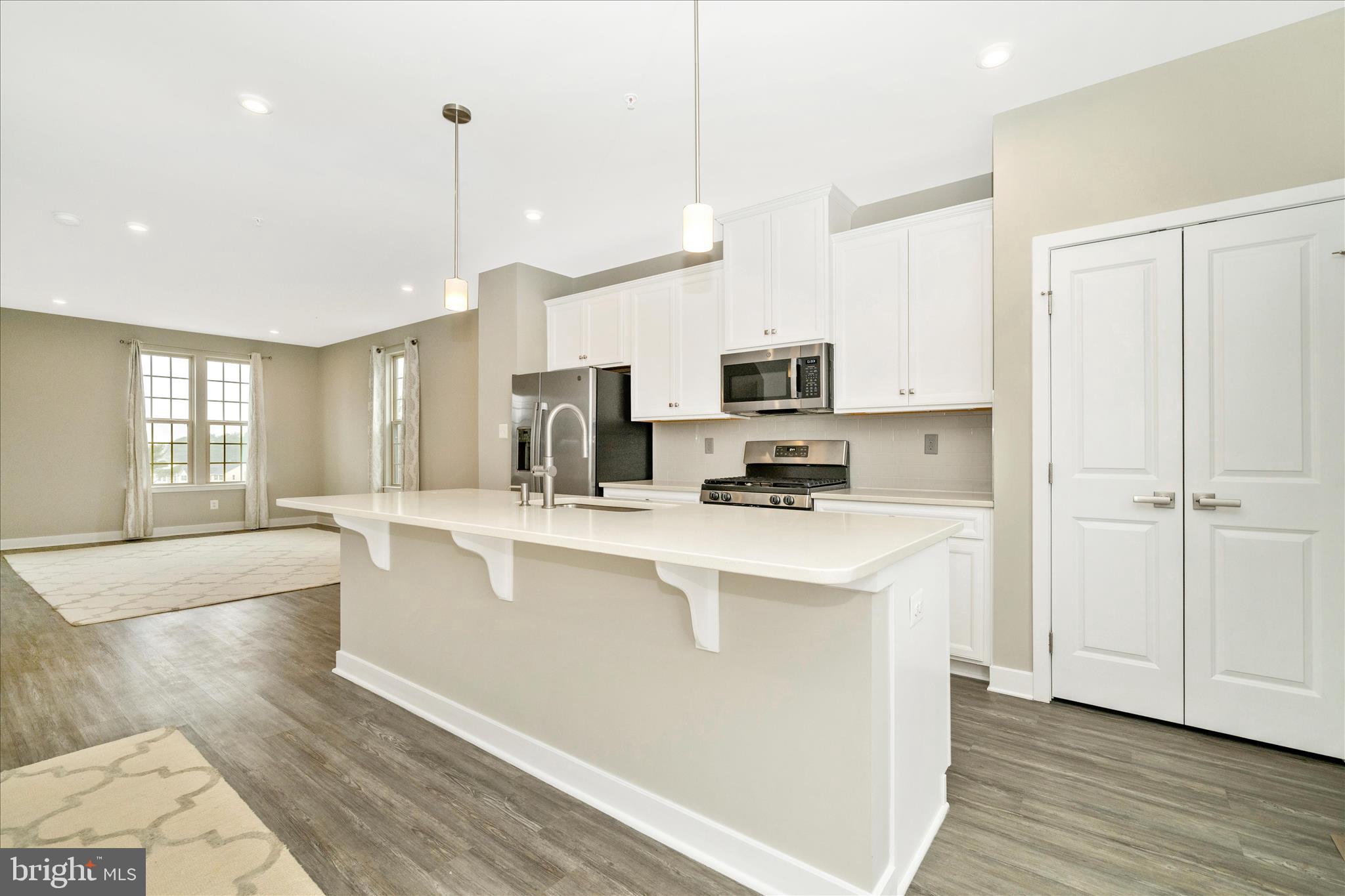 9537 Tall Oaks Road Montgomery Village, MD 20886 - Photo 19 of 53 a kitchen with stainless steel appliances a stove top oven a sink a refrigerator a center island and cabinets