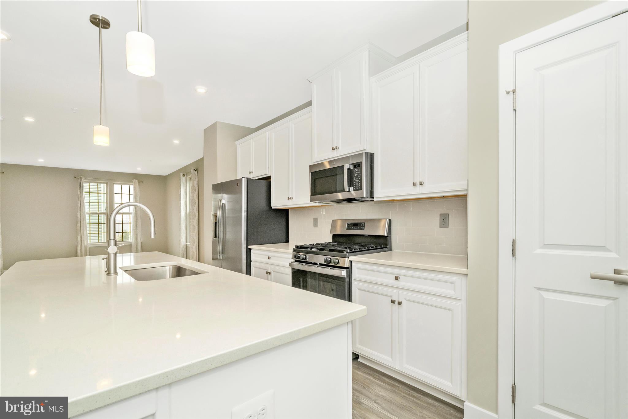9537 Tall Oaks Road Montgomery Village, MD 20886 - Photo 22 of 53 a kitchen with stainless steel appliances granite countertop a sink a stove a refrigerator and white cabinets