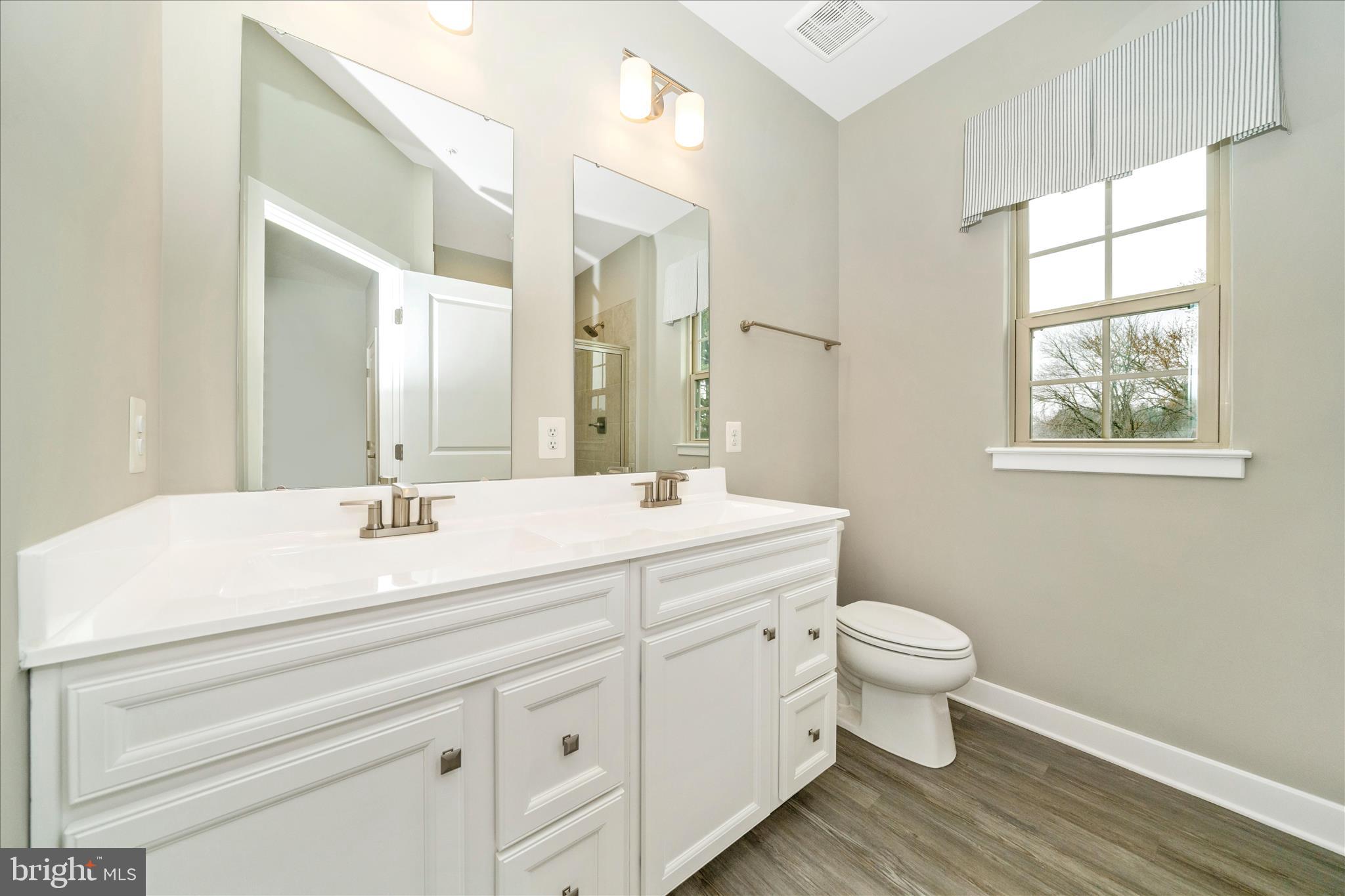 9537 Tall Oaks Road Montgomery Village, MD 20886 - Photo 29 of 53 a bathroom with a toilet sink a mirror and vanity