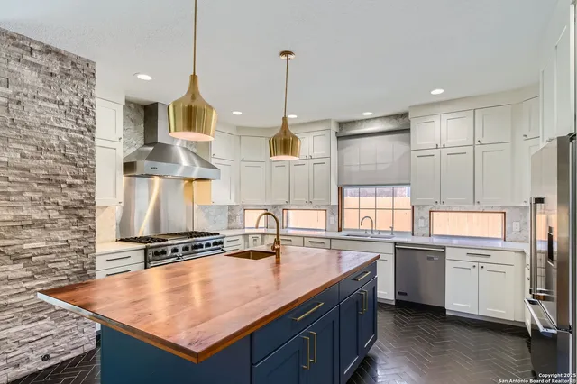 a kitchen that has a lot of cabinets in it and wooden floors