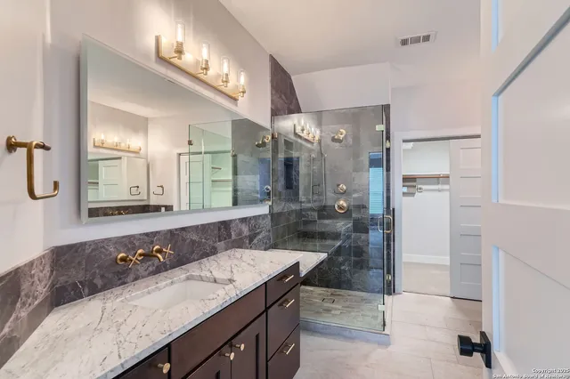 a bathroom with a granite countertop sink and a mirror