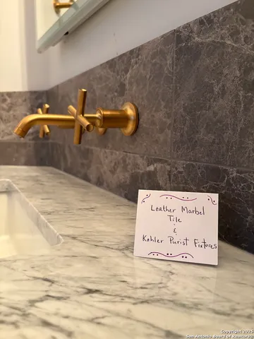 a bathroom with a granite countertop sink and a bathtub