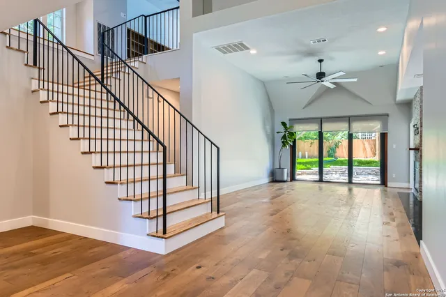 a view of staircase with wooden floor and fan
