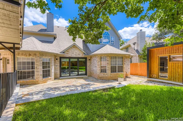 a patio with table and chairs and potted plants