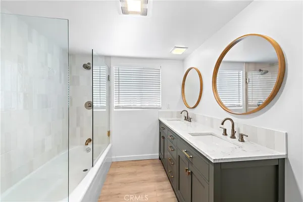 a bathroom with a double vanity sink a mirror and a mirror