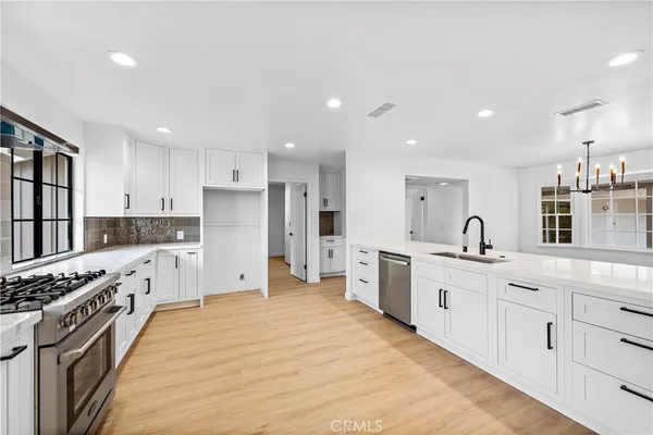 a large kitchen with stainless steel appliances kitchen island granite countertop a stove and a sink