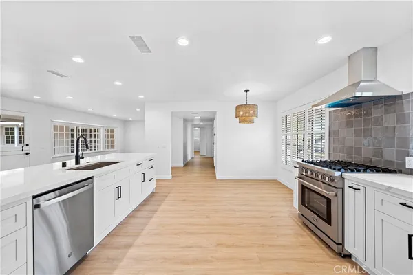 a large kitchen with stainless steel appliances granite countertop a stove and a sink