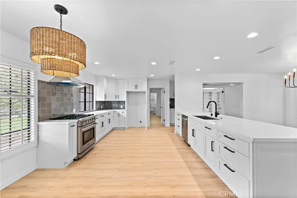 a large kitchen with stainless steel appliances kitchen island granite countertop a stove and a sink
